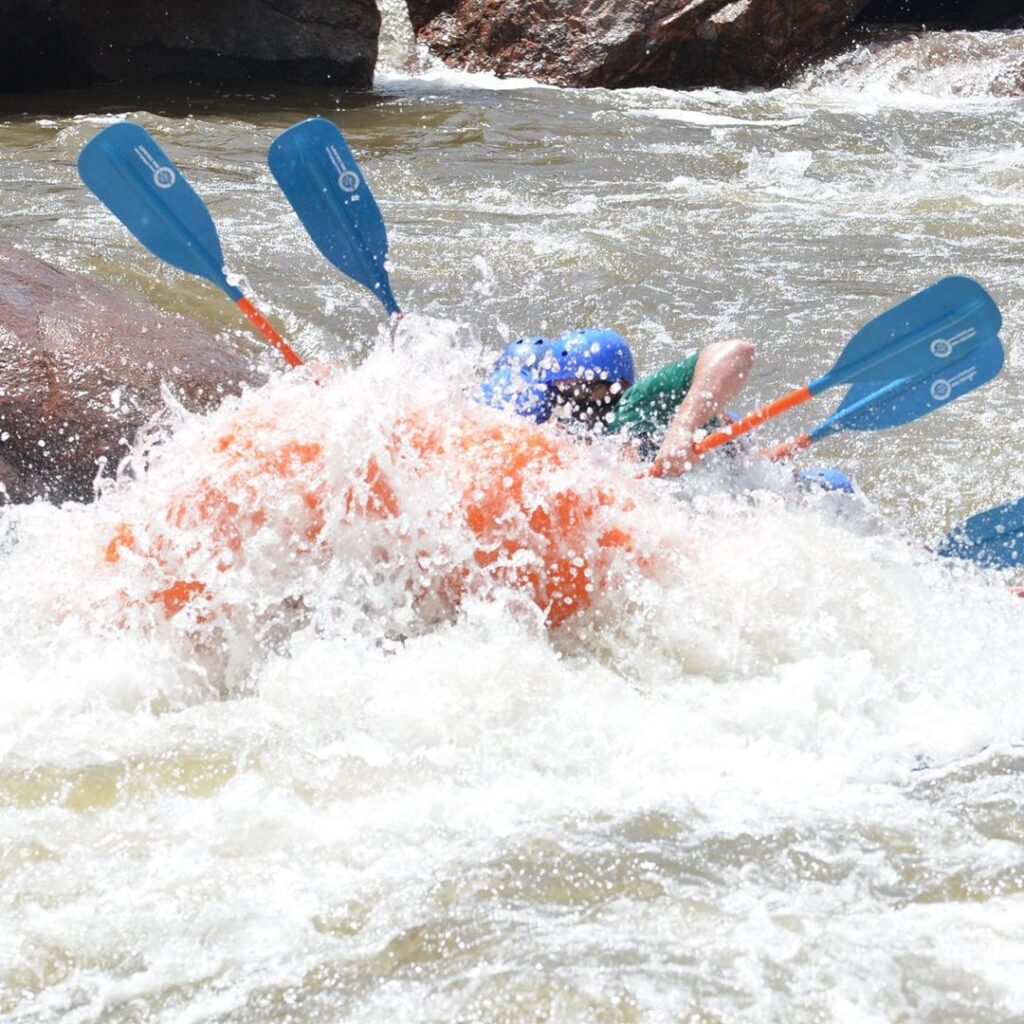 Orange Hyside raft dropping into Sunshine Falls in the Royal Gorge of the Arkansas River, Colorado.